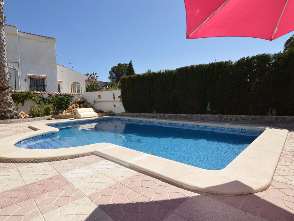 - une piscine dans une cour avec un parasol dans l'établissement Belvilla by OYO Casa Fien, à Rojales