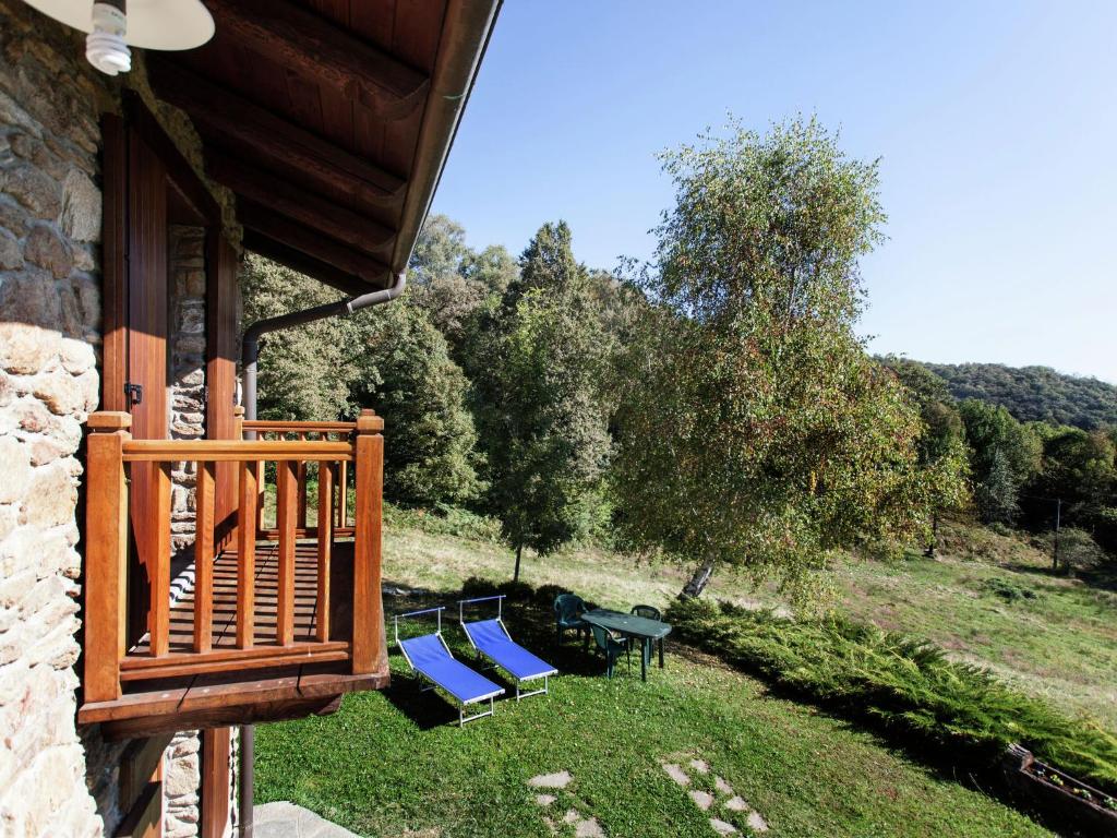 a balcony with blue chairs and a table on the grass at Belvilla by OYO Cascina Paola in Netro