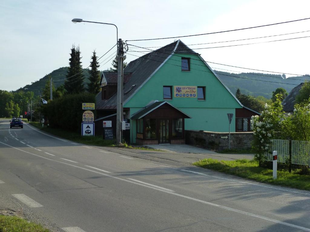 un edificio verde al lado de una carretera en Ubytování Mlýn, en Velké Losiny