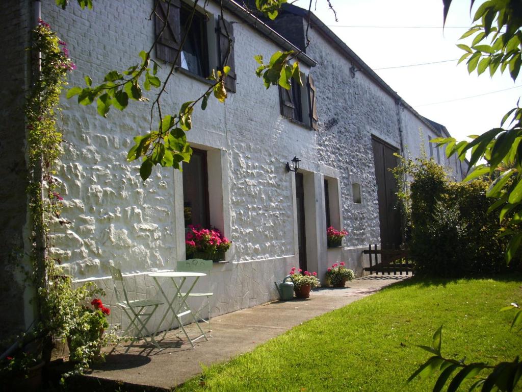 un edificio blanco con una mesa delante en Nice g te with private garden in Br ly de Pesche, en Couvin