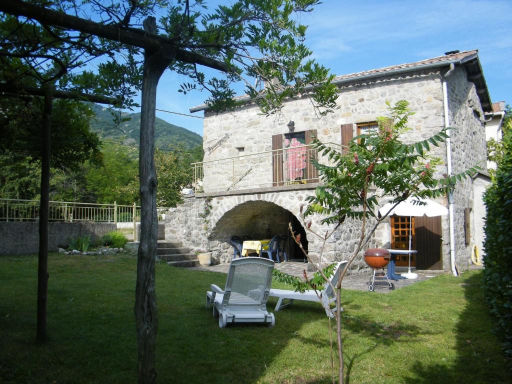 ein Steinhaus mit einem Pizzaofen im Hof in der Unterkunft Cosy holiday home on the river Le Lignon in La Souche