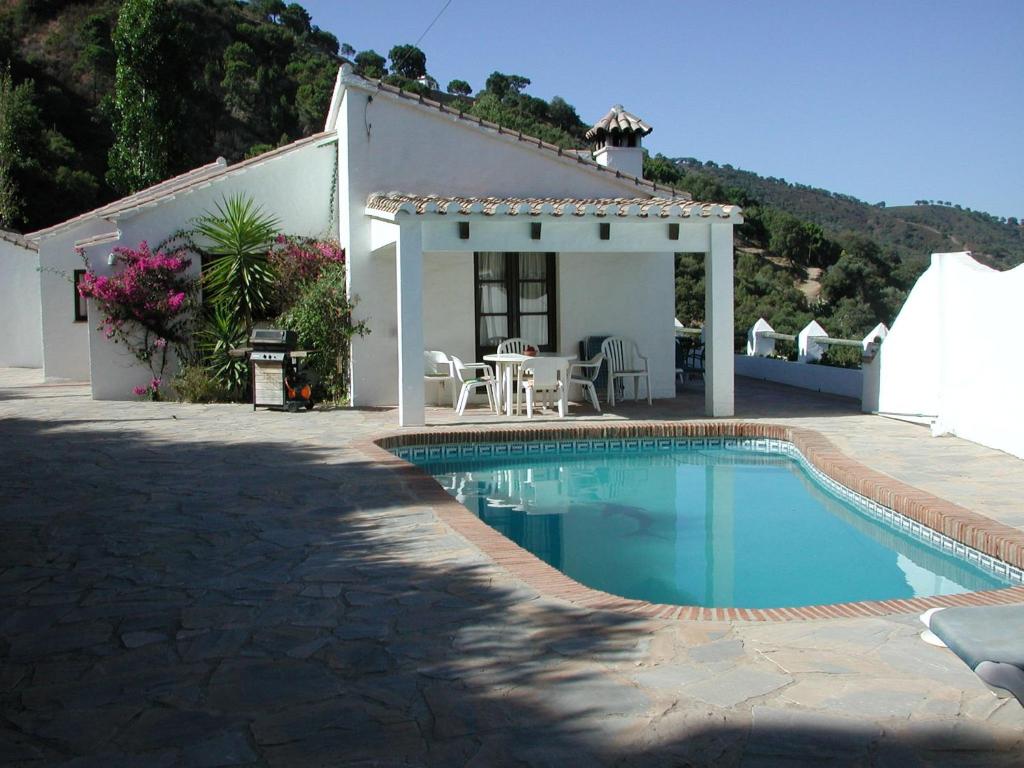 a villa with a swimming pool in front of a house at Belvilla by OYO Las Cerezas in Casares