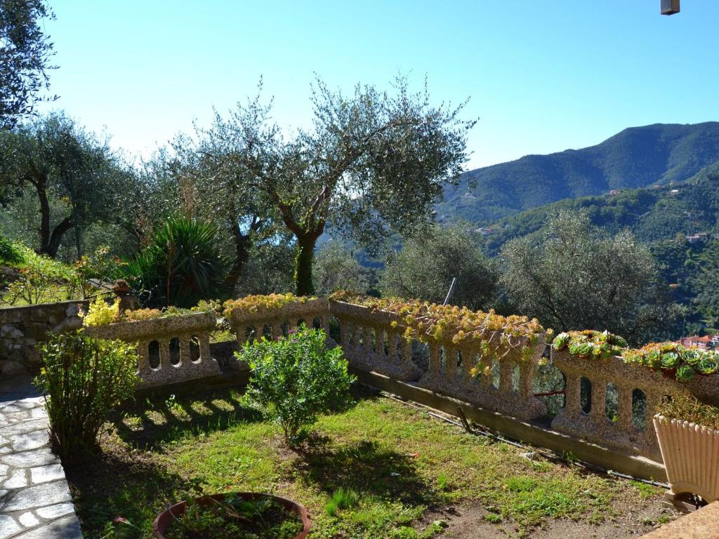 kamienna ściana z kwiatami z górami w tle w obiekcie Villa in Moneglia near the Sea and Hillside w mieście Moneglia