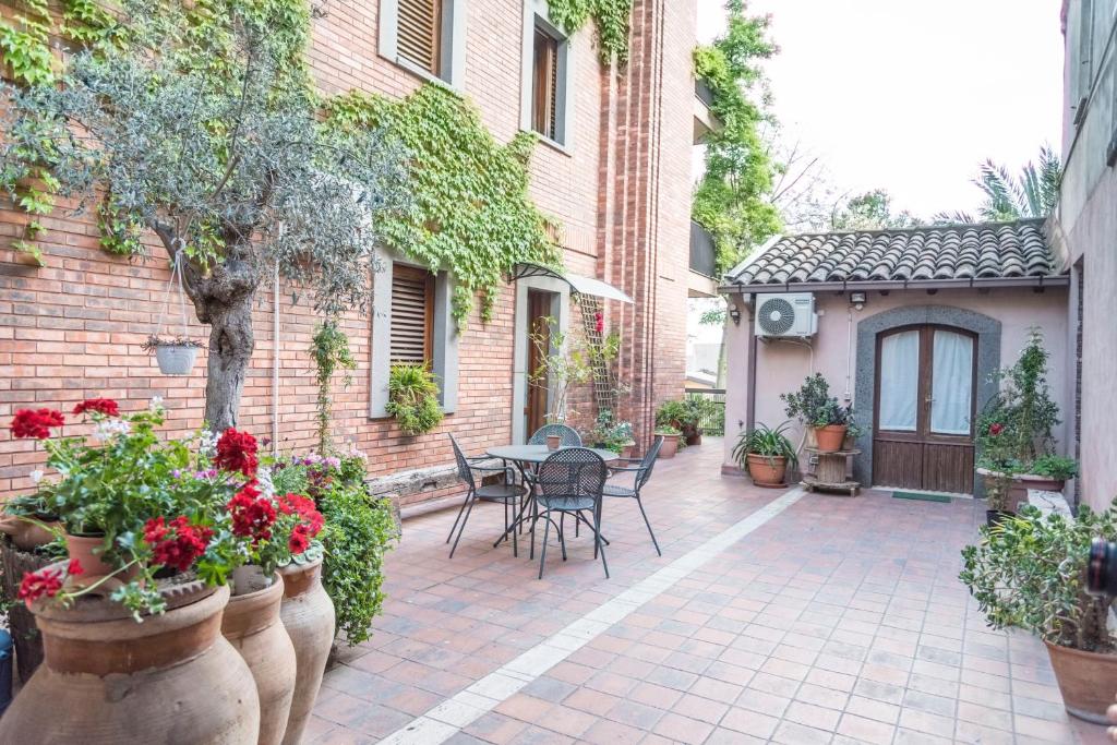 an outdoor patio with a table and chairs and flowers at Relais Chiesa Madre - Rooms and Apartments in Misterbianco