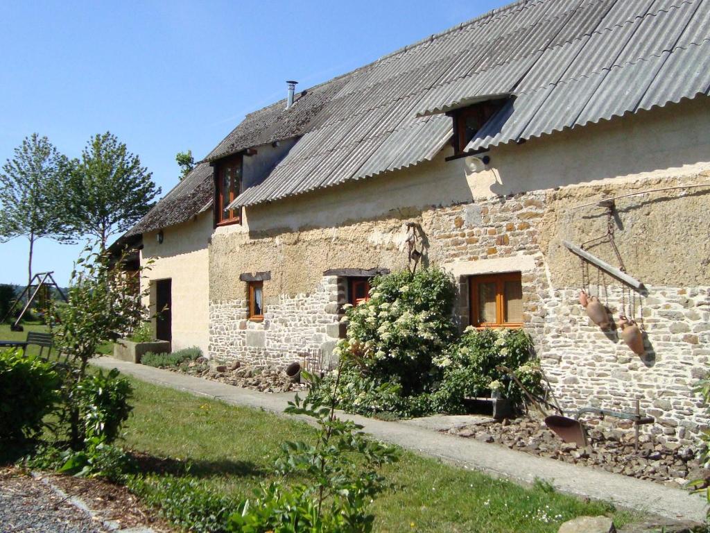 ein altes Steinhaus mit Metalldach in der Unterkunft Rustic holiday home with garden in Normandy in Gouvets