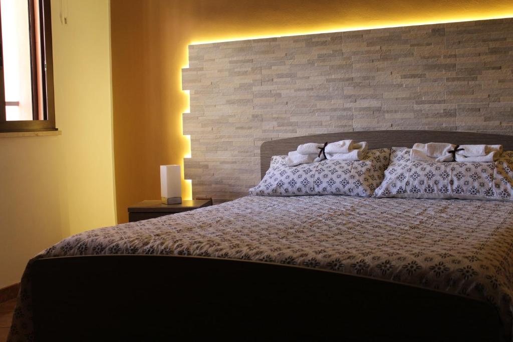 una camera con un grande letto con un muro di mattoni di Green House di Ingoglia a Marsala
