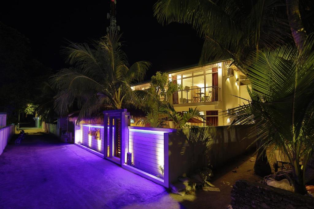 una casa con luces moradas delante de ella en Shallow Lagoon Rasdhoo, en Rasdu