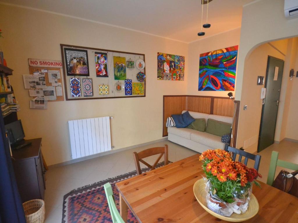 a living room with a table with a vase of flowers on it at Belvilla by OYO An apartment near the sea in Finale Ligure