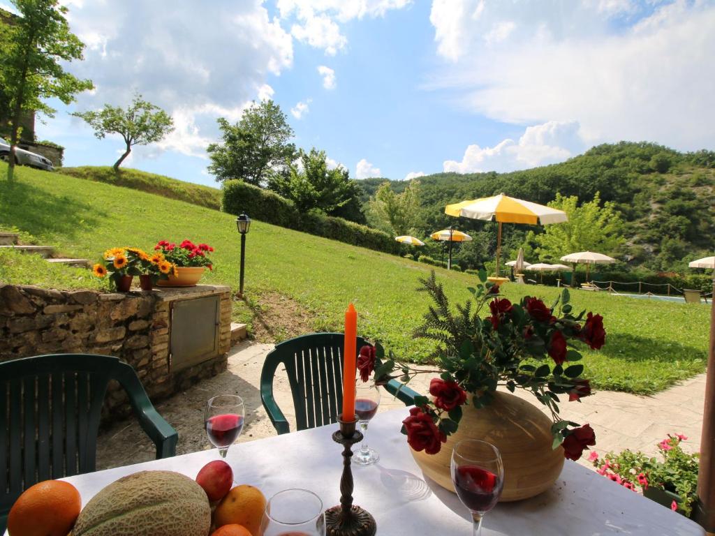 una mesa con fruta y un jarrón de flores. en Belvilla by OYO Orzo, en Apecchio