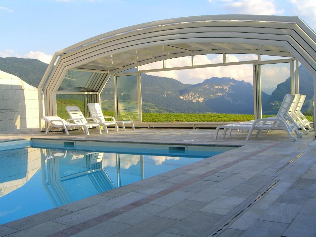 einen Pool mit Stühlen und einem Pavillon in der Unterkunft Belvilla by OYO Villa Stenico in Steinig