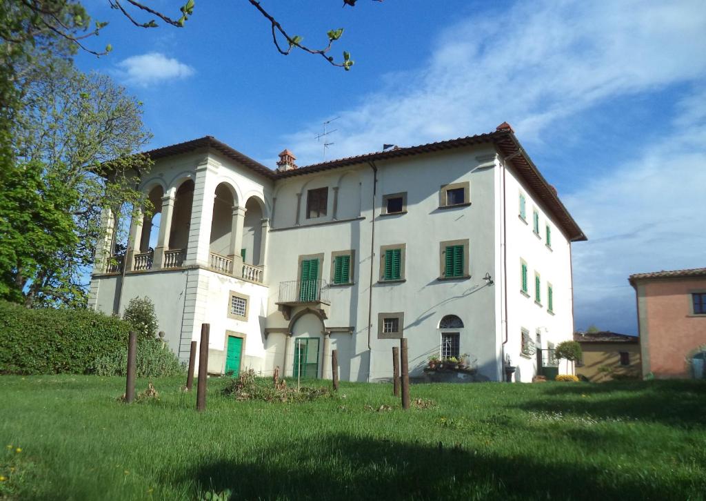 un grand bâtiment blanc sur une pelouse dans l'établissement Agriturismo Albergotti, à Arezzo