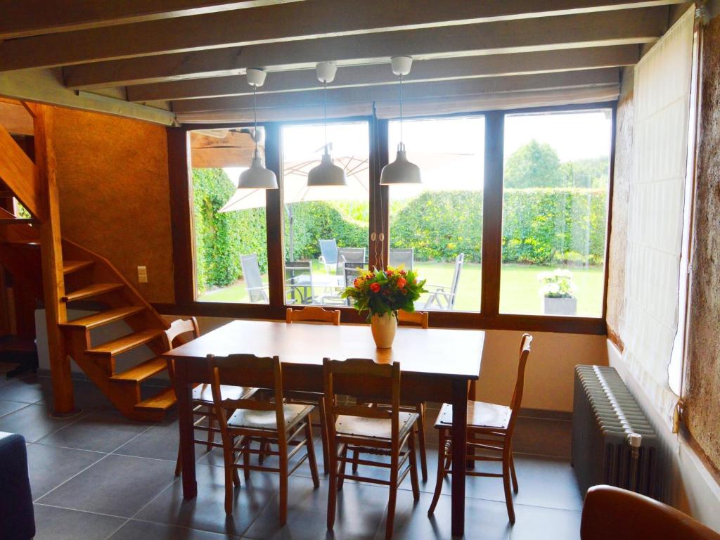 a dining room with a table and chairs and a window at With a broad view over the hilly landscape in Flobecq