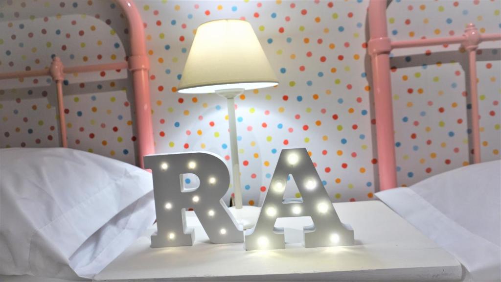 a bedroom with a bed with a sign and a lamp at El Rincon de Ale in Cuenca