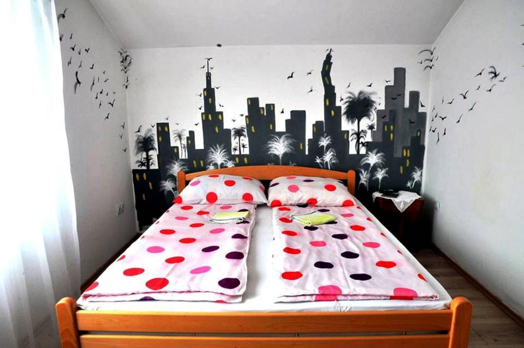 a bedroom with a bed with a city mural on the wall at Hostel Room in Banja Luka