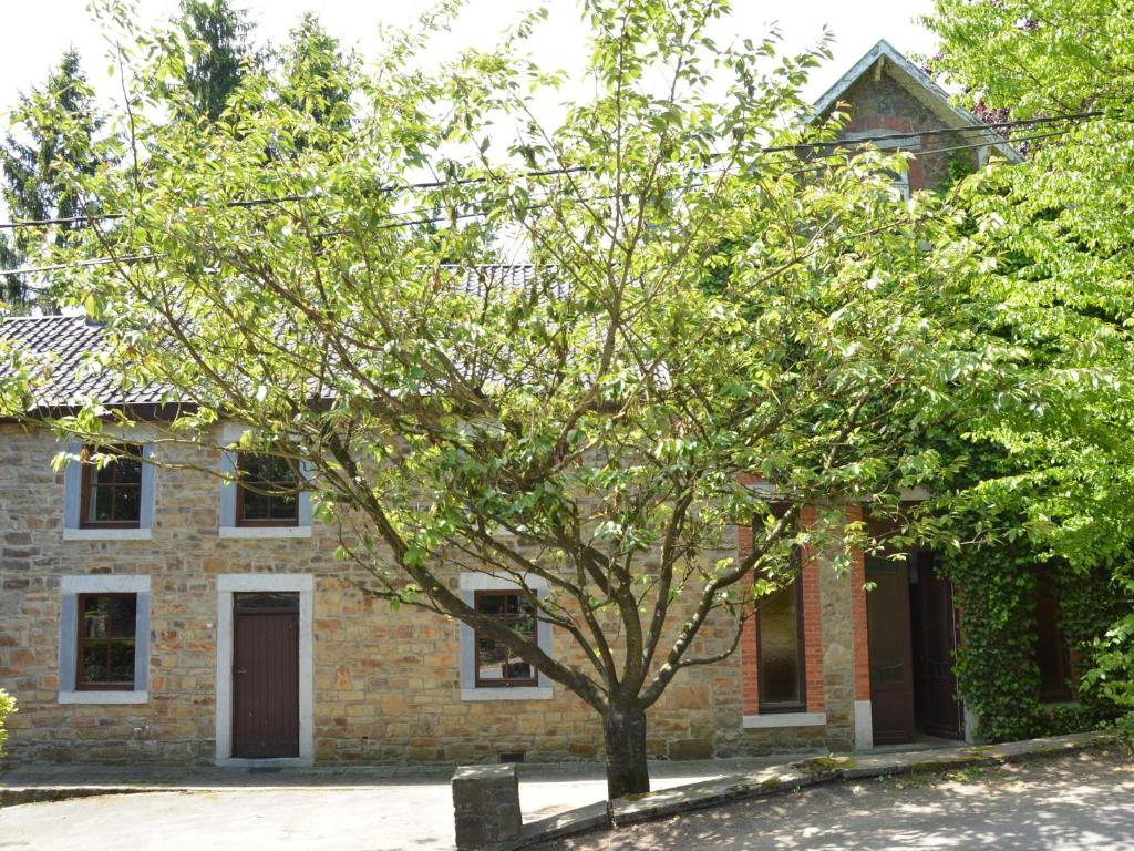 a brick house with a tree in front of it at This plain house is very suitable for groups in Ferrières