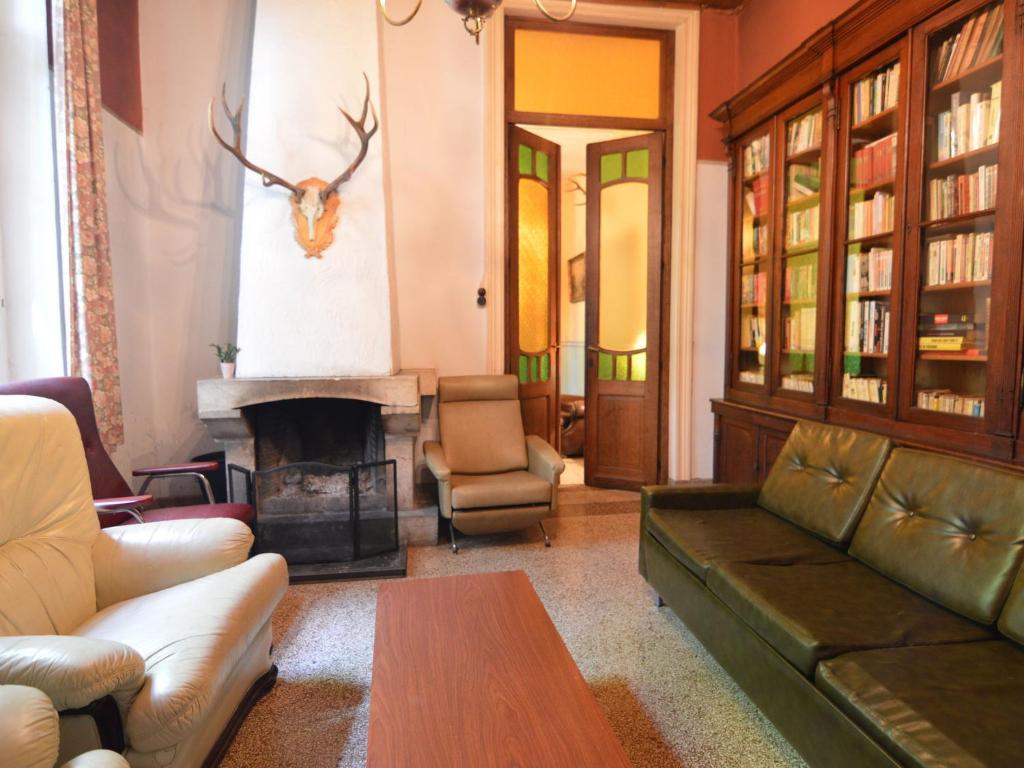 a living room with a couch and a fireplace at This plain house is very suitable for groups in Ferrières