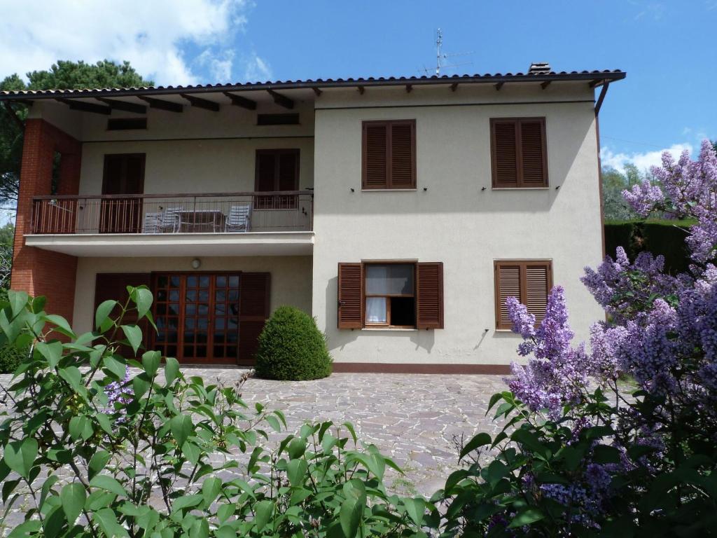 マジョーネにあるBelvilla by OYO Casa Miralagoの紫の花が咲くバルコニー付きの家