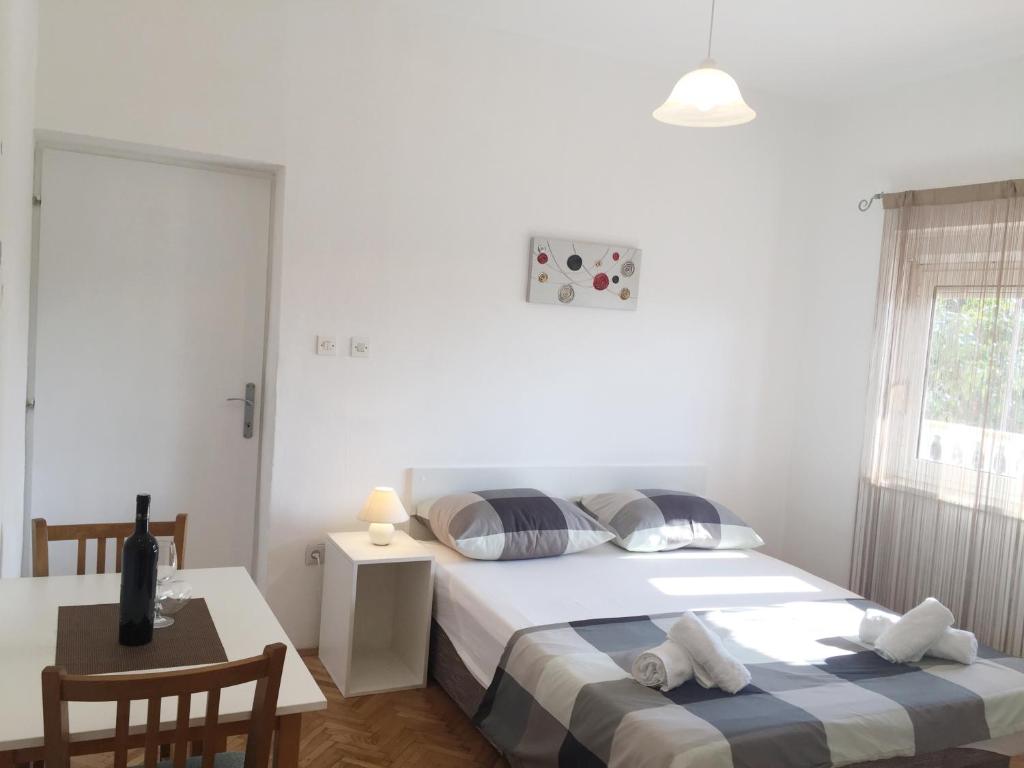 une chambre avec deux lits et une table et une fenêtre dans l'établissement Apartment Nina, à Zadar