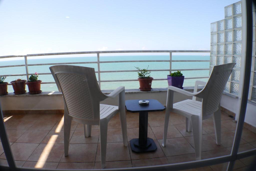 two chairs and a table on a balcony with a view at Espana aparthotel in Durrës