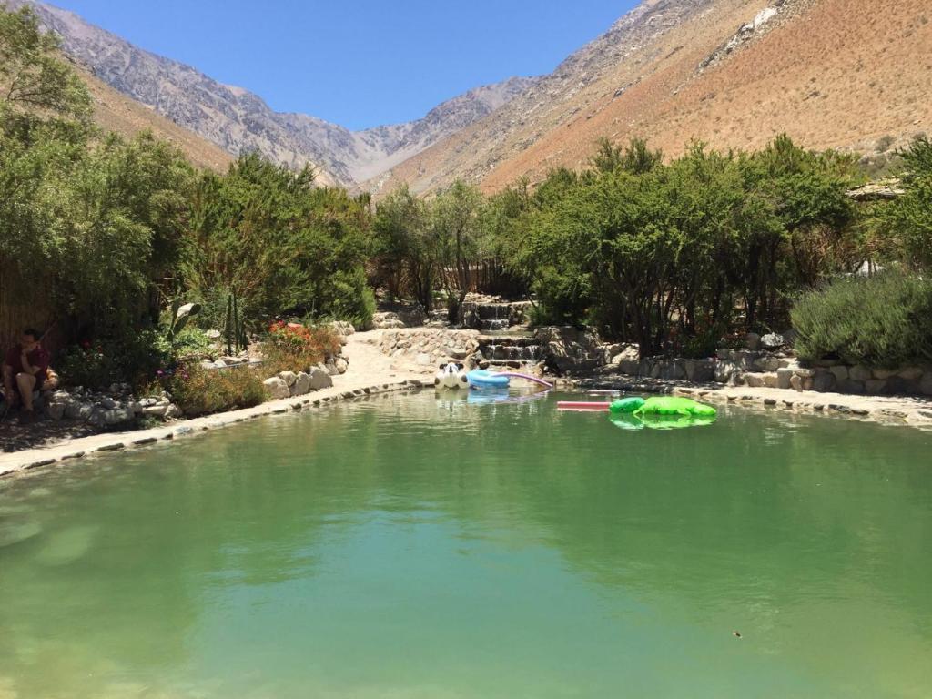 uma piscina de água verde num rio com montanhas em Cabañas Luna de Cuarzo, Cochiguaz em Paiguano