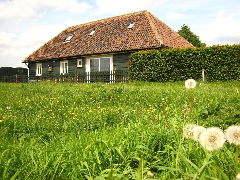 uma casa com um campo de relva e flores em Charming Holiday Home in Zele near the Forest em Zele