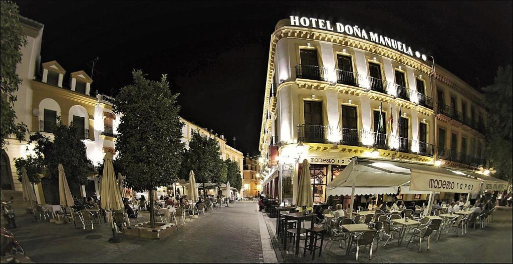 una calle con mesas y sillas frente a un edificio en Basic Hotel Doña Manuela en Sevilla