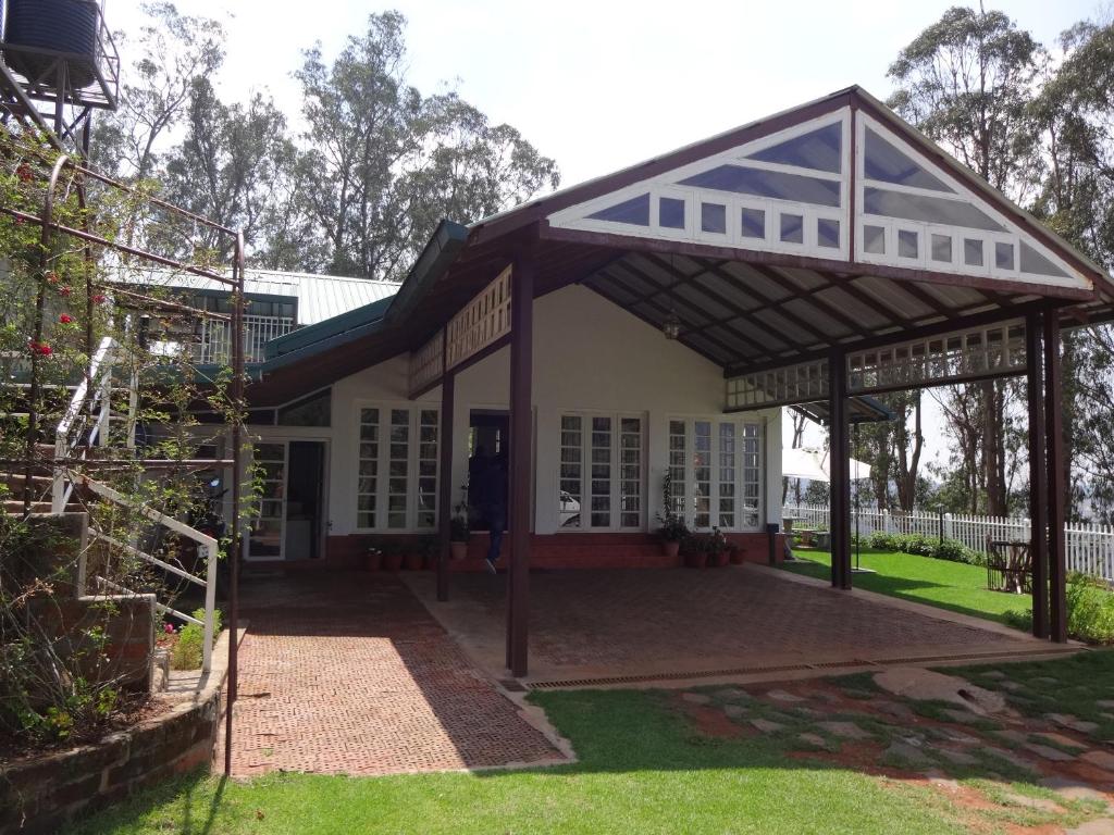 una casa independiente con un pabellón en un patio en Irinjalakuda House, en Ooty