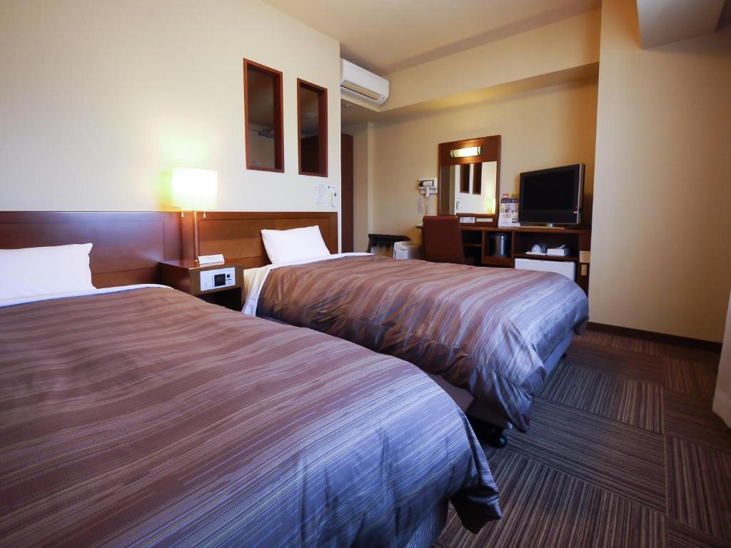Postel nebo postele na pokoji v ubytování Hotel Route-Inn Gotenba Eki-Minami