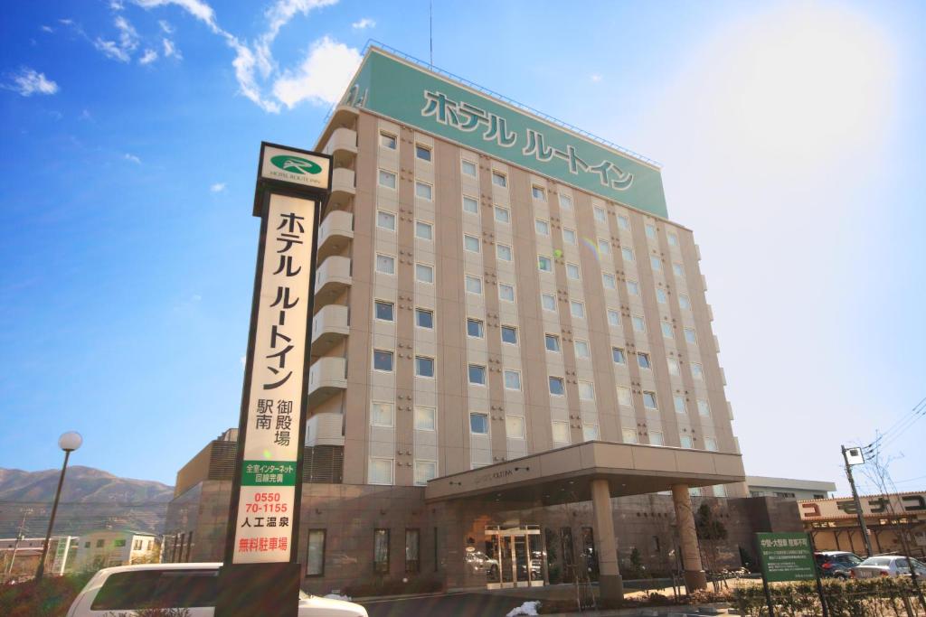 un bâtiment d'hôtel avec un panneau devant lui dans l'établissement Hotel Route-Inn Gotenba Eki-Minami, à Gotemba