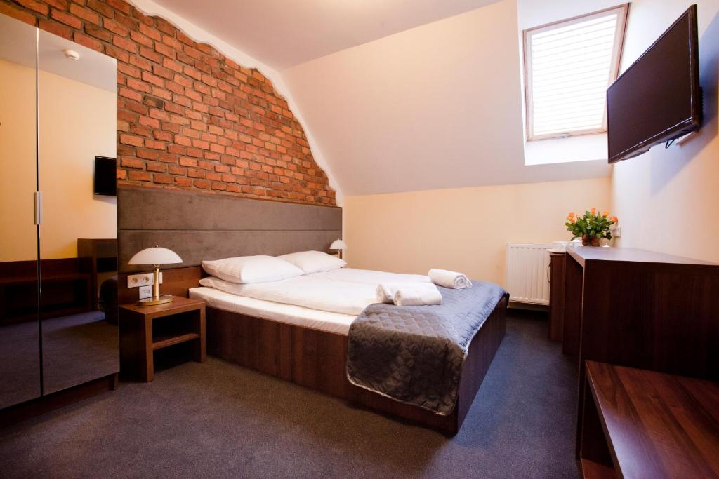 sypialnia z łóżkiem i ceglaną ścianą w obiekcie Aparthotel W Pałacu w Krakowie