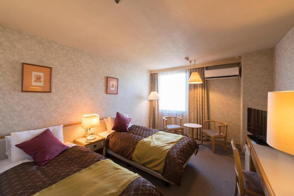 Postel nebo postele na pokoji v ubytování Sky Hotel Uozu