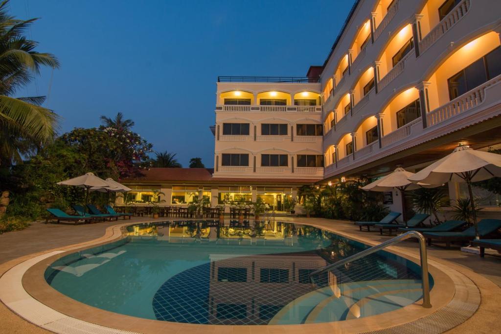 a hotel with a swimming pool in front of a building at Khemara Angkor Hotel & Spa in Siem Reap