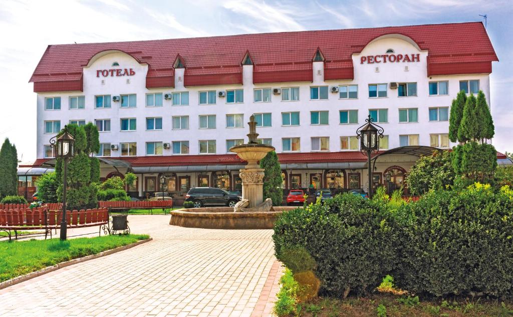 a hotel building with a fountain in front of it at Готель "Дубно" in Dubno