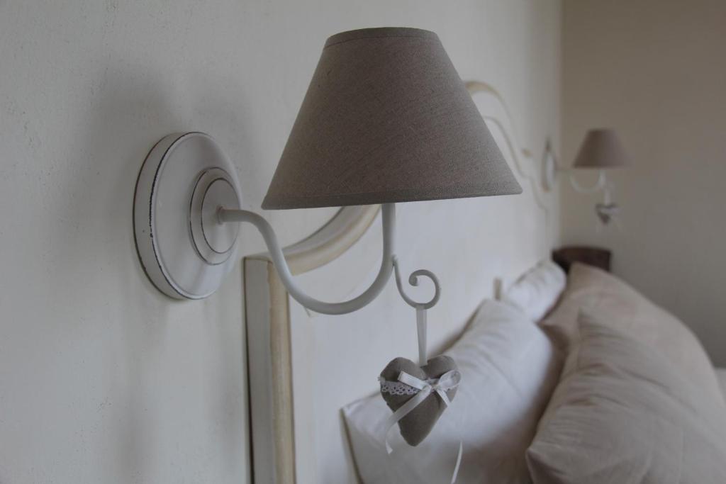 eine Lampe mit einem Bogen neben einem Bett in der Unterkunft B&B CAMPAGNON VALPOLICELLA in SantʼAmbrogio di Valpolicella