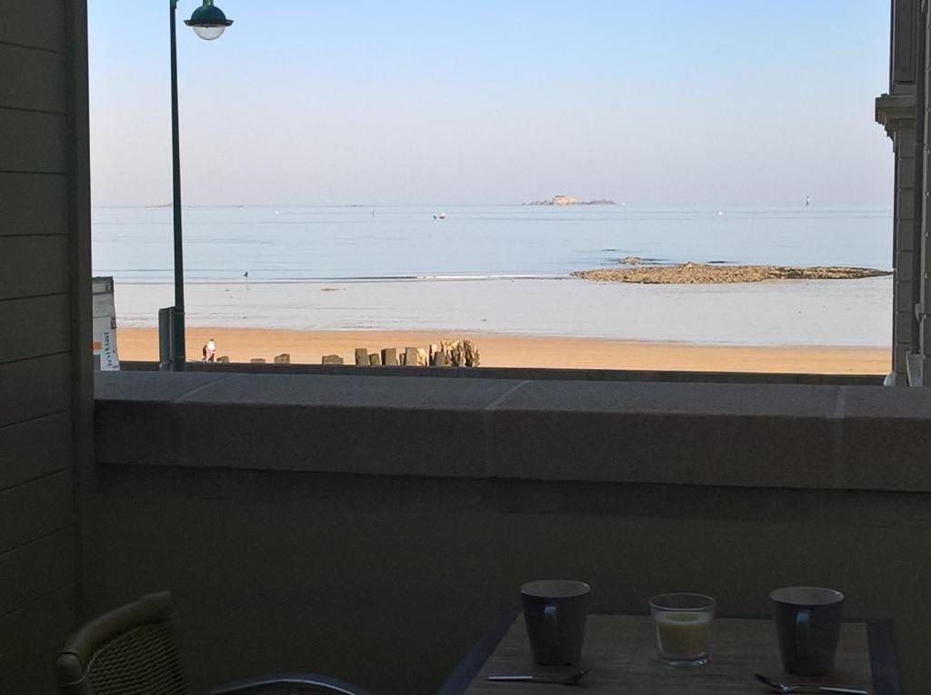 a view of the beach from a restaurant window at Studio Le sillon malouin vue mer in Saint Malo