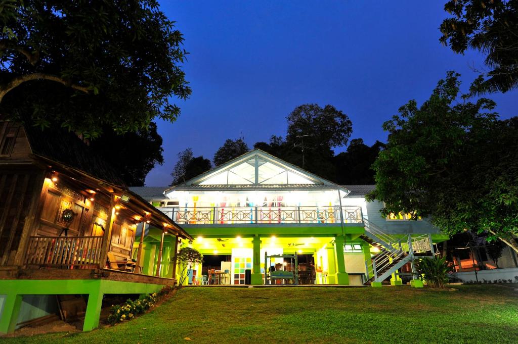 a lit up building with a balcony at night at Kapitan Lodge in Port Dickson