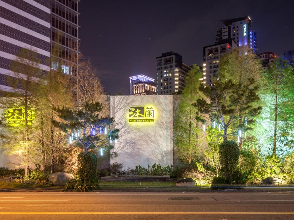 un bâtiment avec un panneau sur son côté la nuit dans l'établissement Mulan Motel, à Taichung