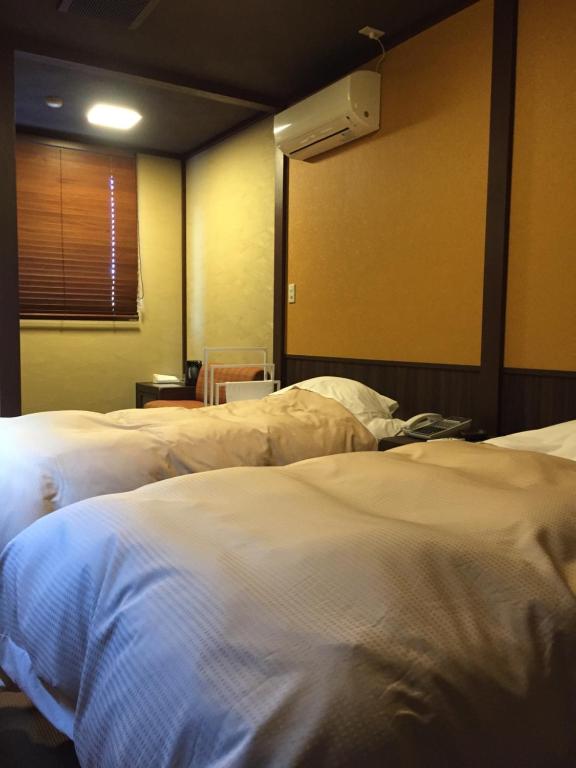 Postel nebo postele na pokoji v ubytování Tokiwa Ryokan