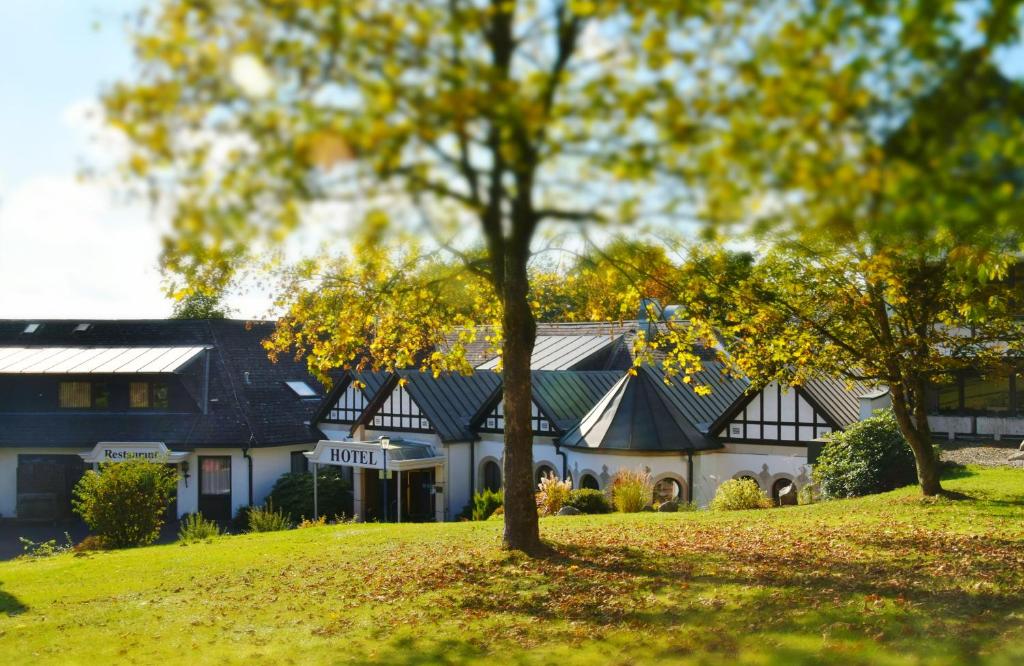 una casa en una colina con árboles en primer plano en Hotel Reiterhof en Wirsberg