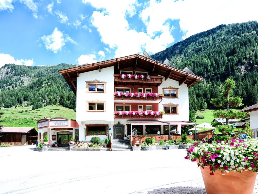 a large building with flowers in front of it at Alpenhof Pitztal in Sankt Leonhard im Pitztal
