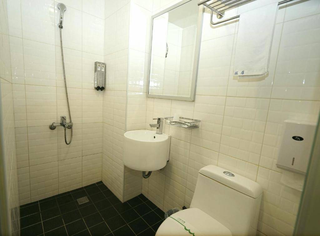 a white bathroom with a toilet and a sink at Century Hotel in Kaohsiung