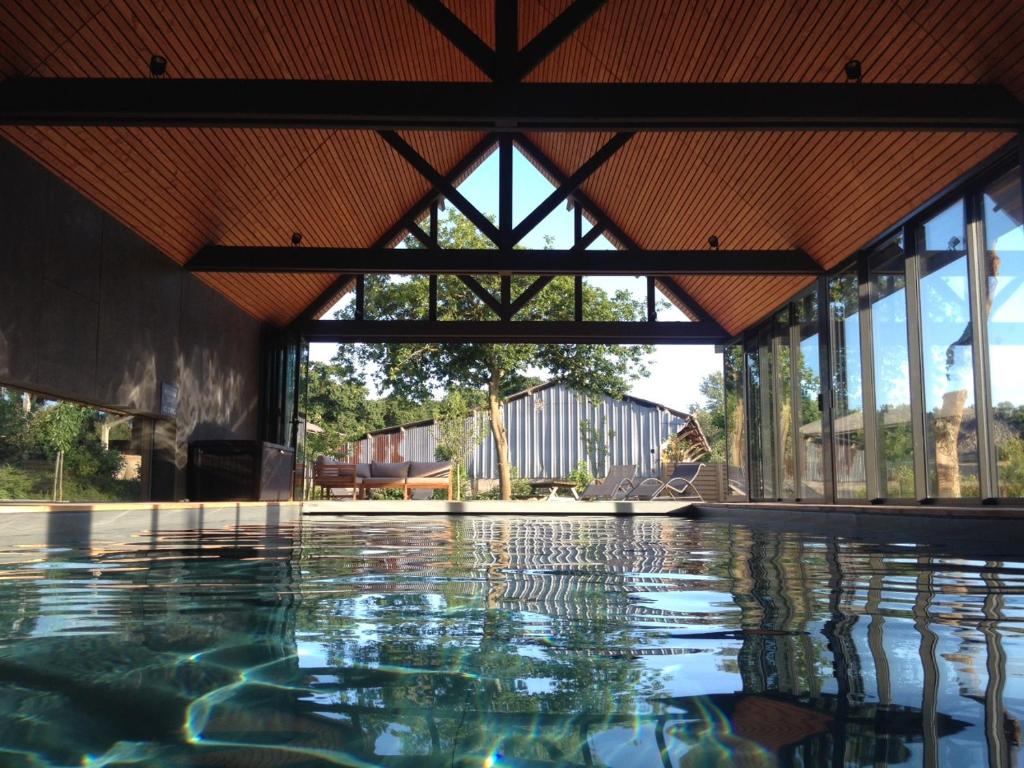 une piscine vide dans un bâtiment avec toit dans l'établissement Domaine du Grenier, à Yffiniac