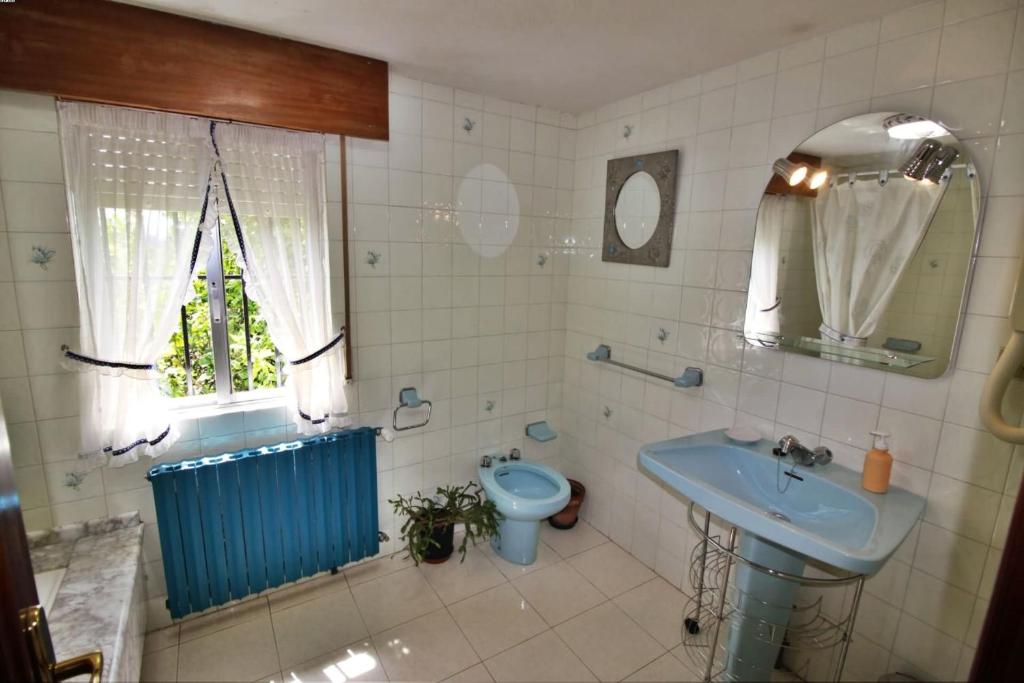 łazienka z błękitną umywalką i toaletą w obiekcie Casa Cunha w mieście Cornanda