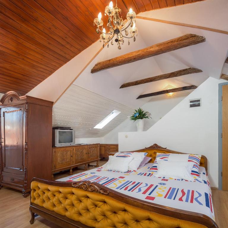 a bedroom with a large bed and a chandelier at Apartment Patricia in Trogir