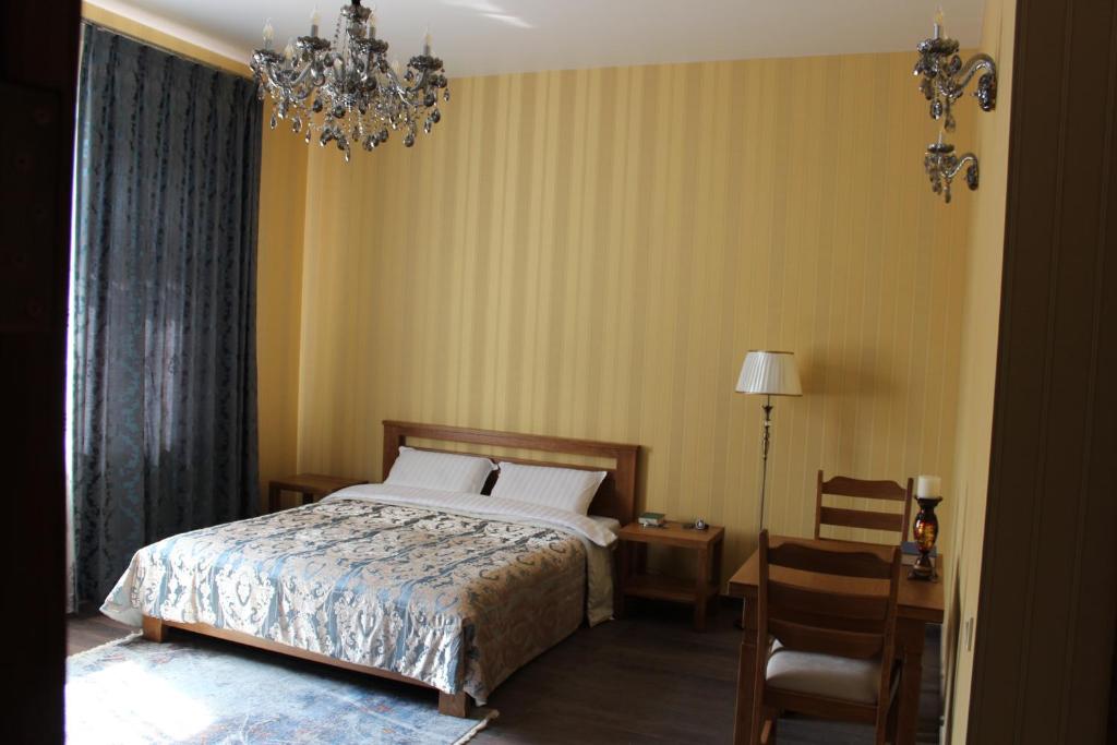 a bedroom with a bed and a chair and a chandelier at Barin House in Sumy