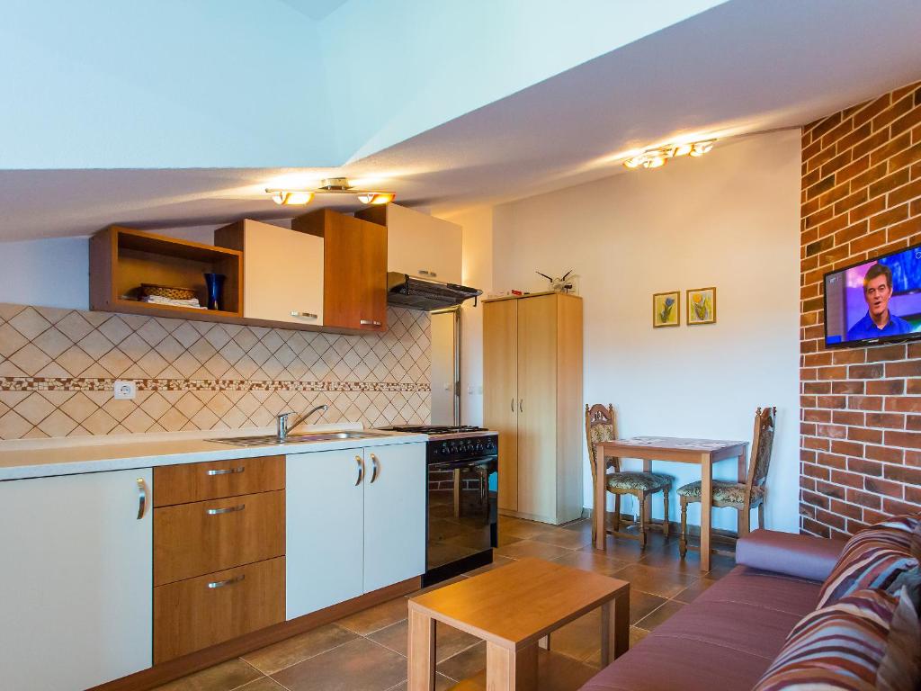a kitchen and living room with a table and a couch at Apartments Špadići in Poreč