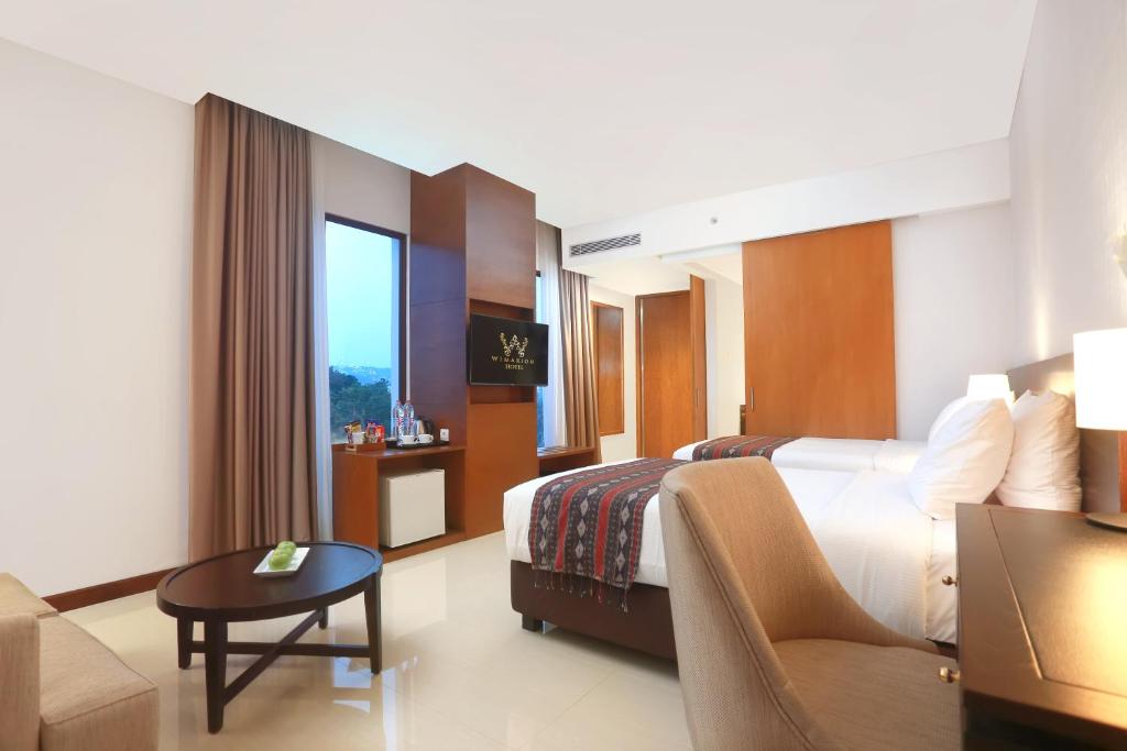 Postel nebo postele na pokoji v ubytování Wimarion Hotel Semarang