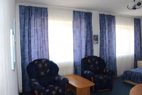 a bedroom with two chairs and a bed and a window at Zhovtnevyi in Vinnytsya