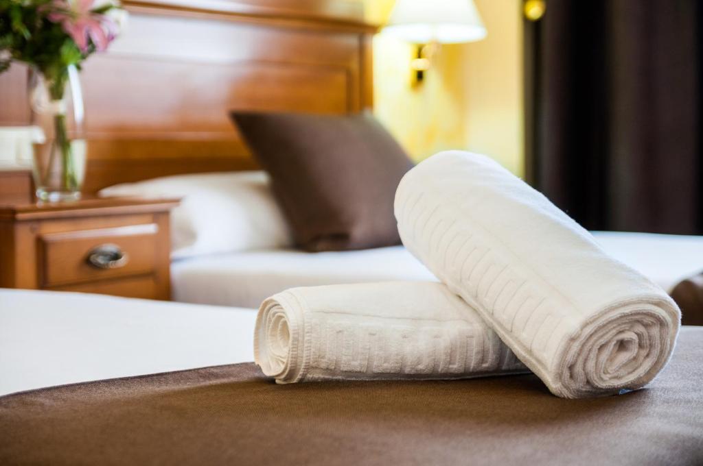 een stapel handdoeken zittend op een bed bij Carlos I Toledo in Yuncos