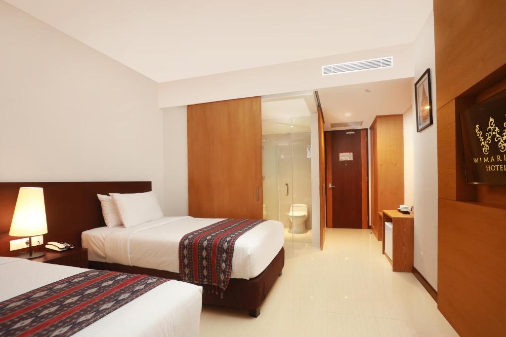 Postel nebo postele na pokoji v ubytování Wimarion Hotel Semarang
